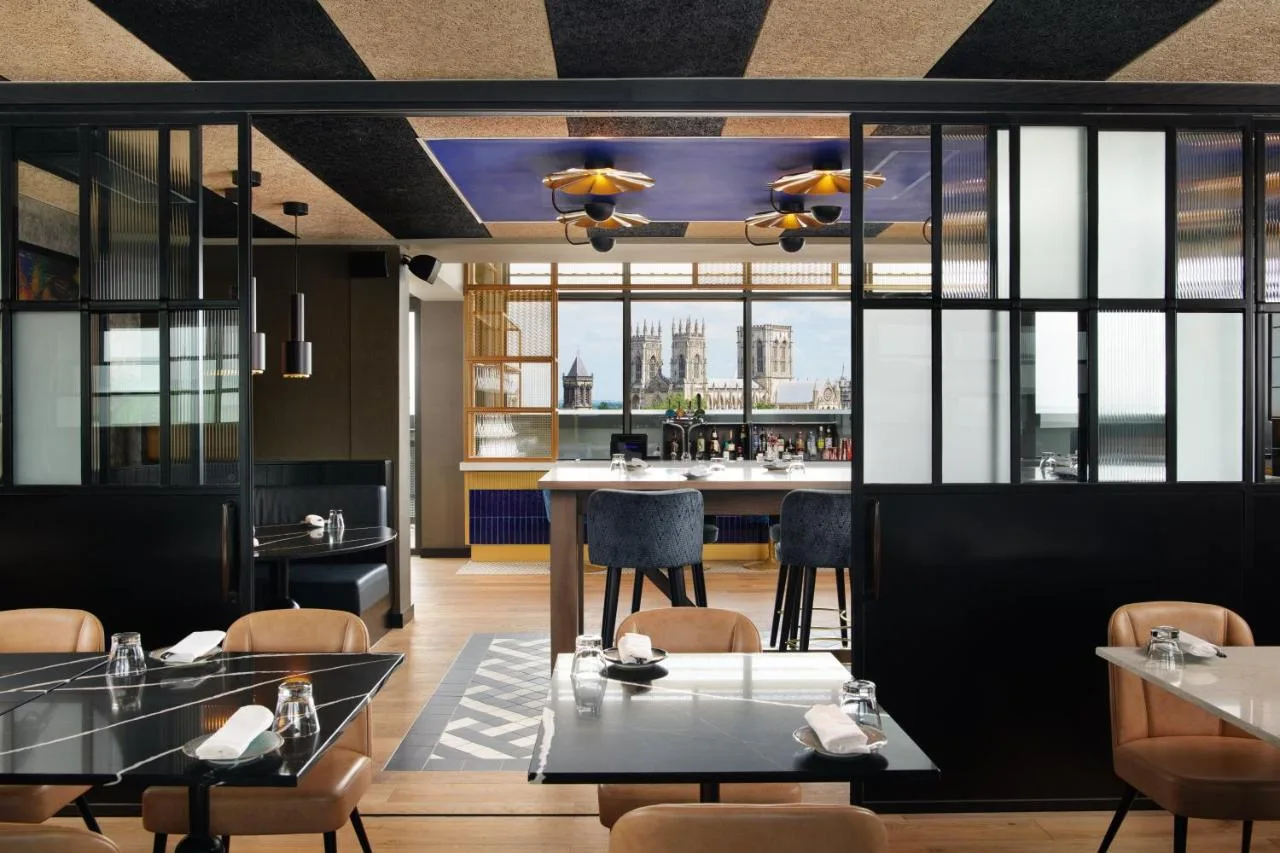 a restaurant with tables and chairs and a bar at Malmaison York in York