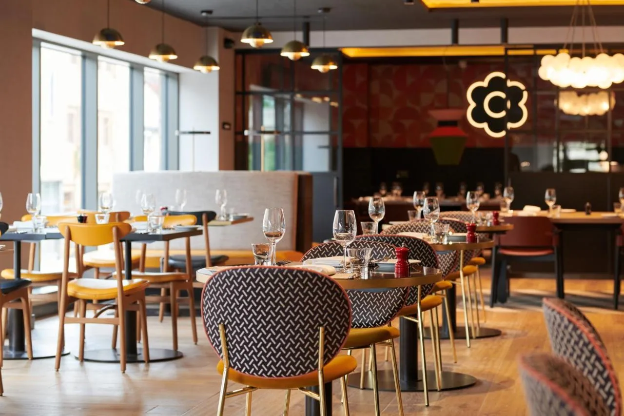 a restaurant with tables and chairs with wine glasses at Malmaison York in York